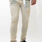 Beige distressed jeans worn by a person on a white background
