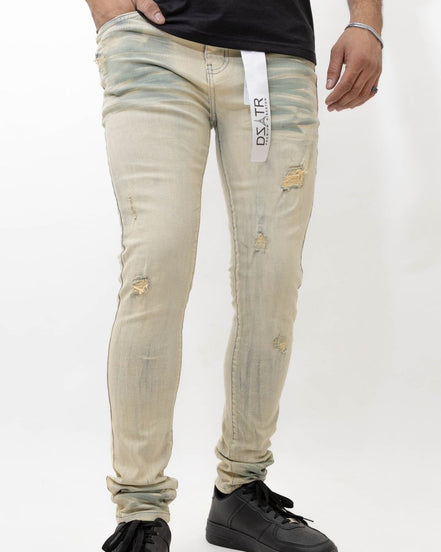 Beige distressed jeans worn by a person on a white background