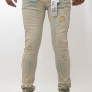 Beige distressed jeans worn by a person on a white background
