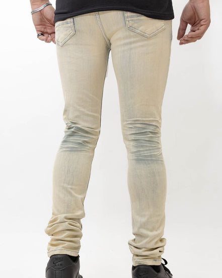 Beige distressed jeans worn by a person on a white background