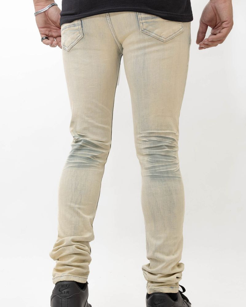 Beige distressed jeans worn by a person on a white background