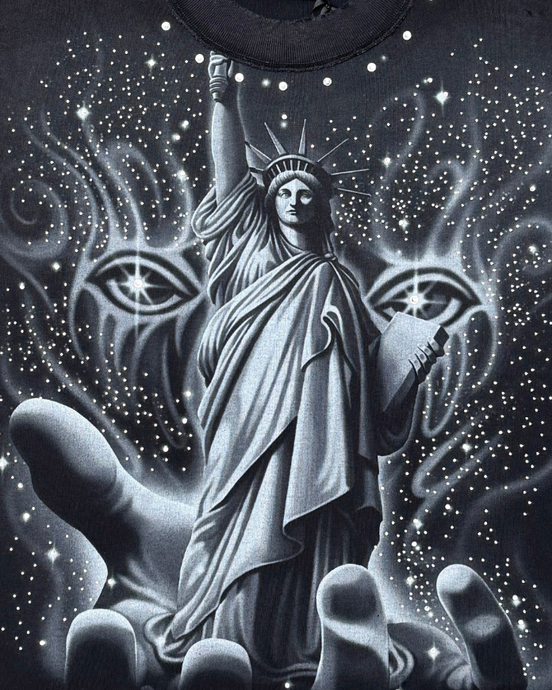 Black t-shirt with a graphic of the Statue of Liberty and mystical elements on a dark background