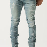 Person wearing light blue distressed jeans and colorful sneakers on a white background