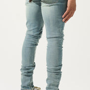 Person wearing light blue jeans and white sneakers on a white background
