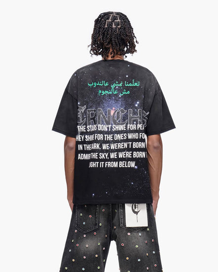 Person wearing a black t-shirt with text on the back, standing against a white background