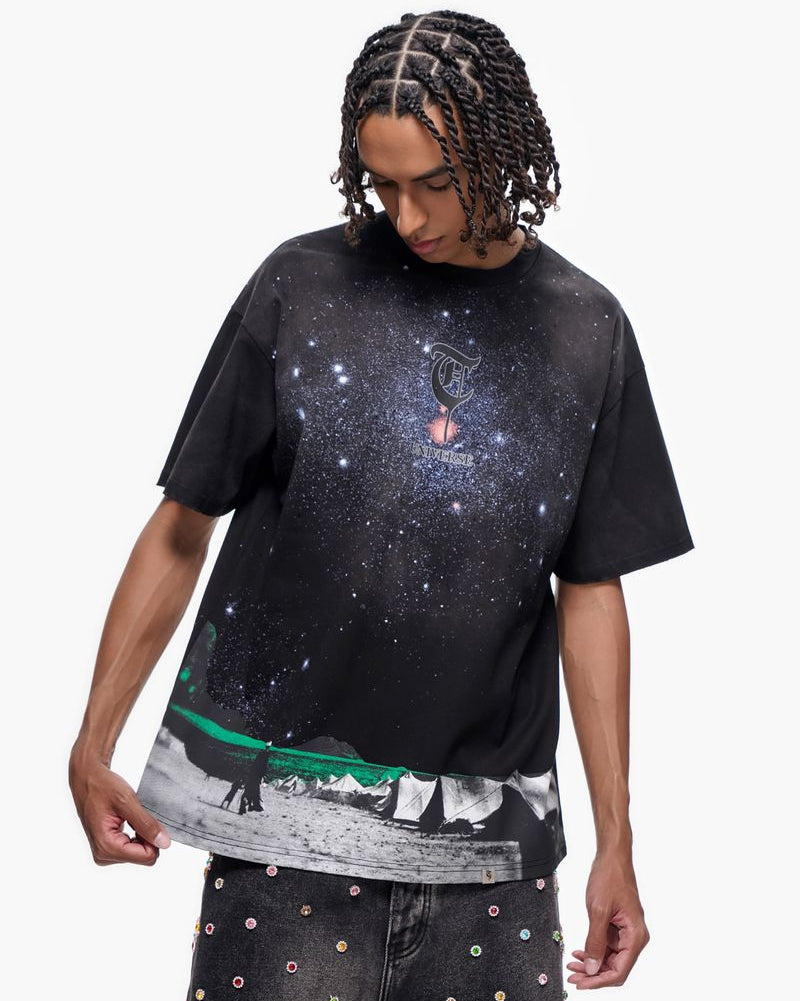 Person wearing a black t-shirt with a galaxy design on a white background