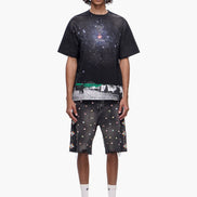 Person wearing a black t-shirt with space-themed design and matching shorts on a white background