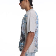 Person wearing a light-colored t-shirt with a graphic design on a white background