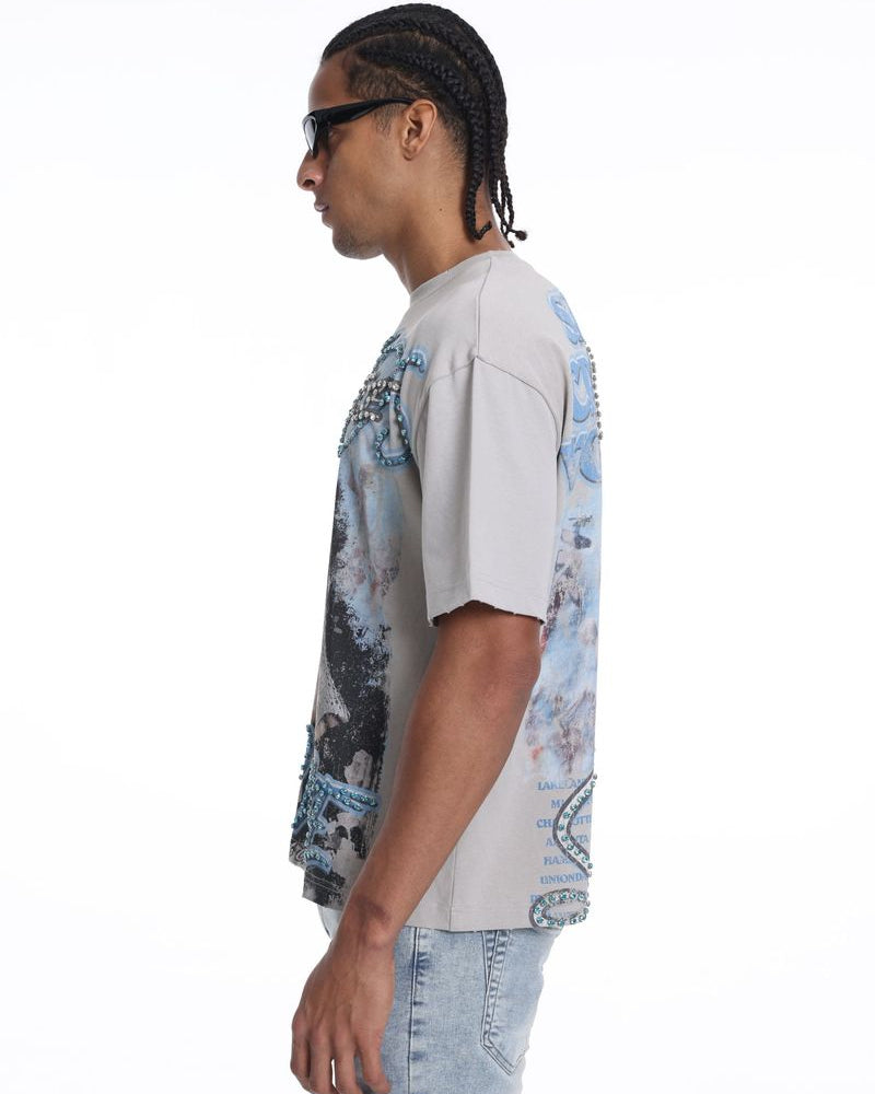 Person wearing a light-colored t-shirt with a graphic design on a white background