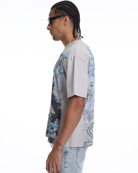 Person wearing a light-colored t-shirt with a graphic design on a white background