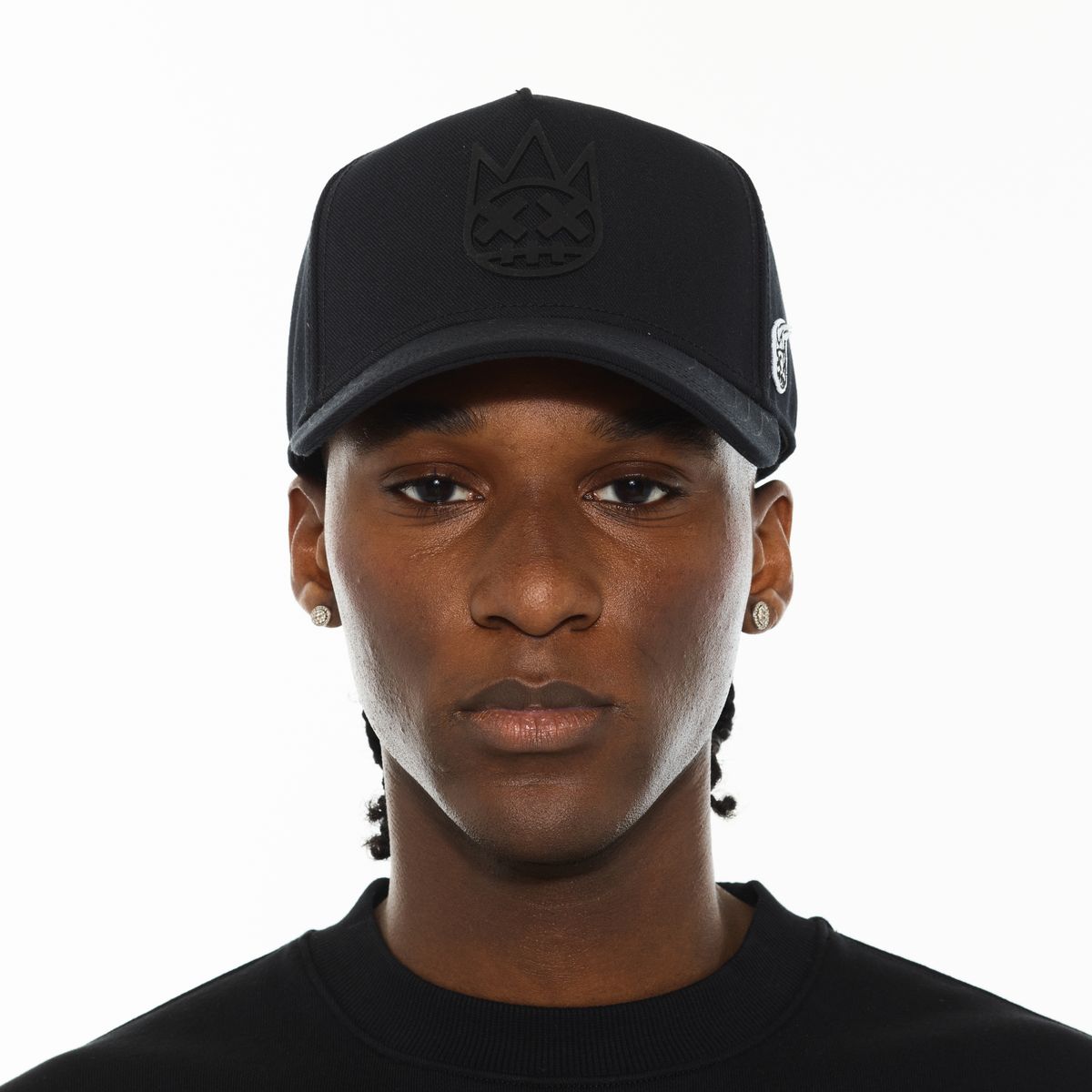 Person wearing a black cap with a logo on a white background