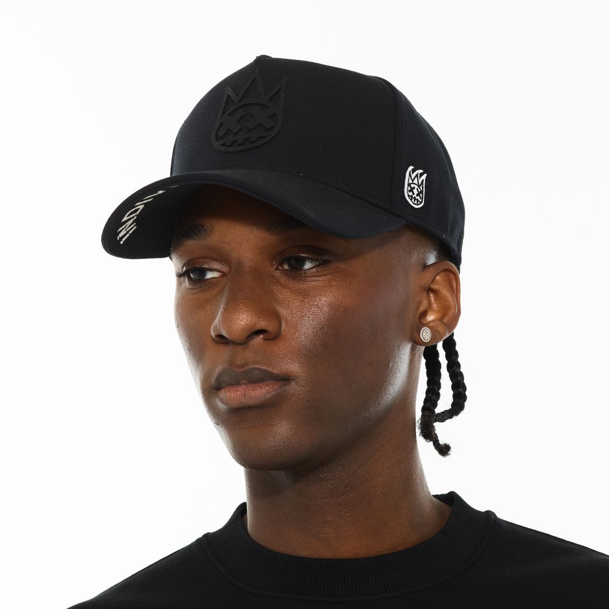 Person wearing a black cap with a logo on a white background