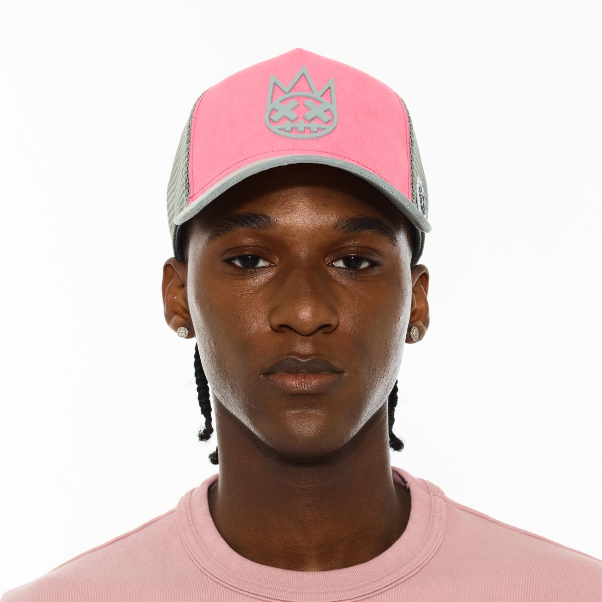 Person wearing a pink and gray cap with a logo on a white background