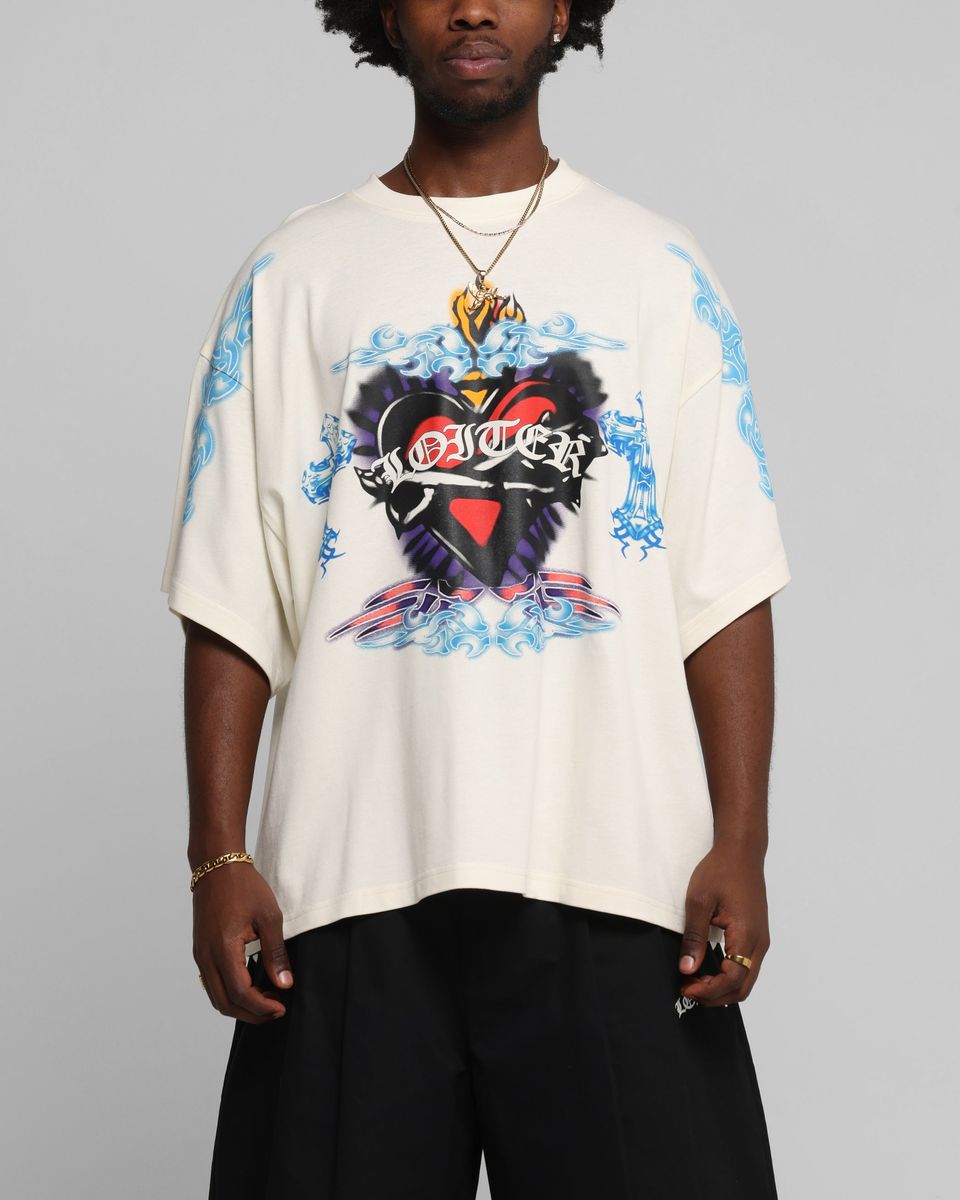 Person wearing a white t-shirt with a colorful graphic design on a gray background