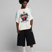Person wearing a colorful graphic t-shirt and black shorts on a gray background