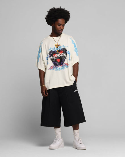 Person wearing a colorful graphic t-shirt and black shorts on a gray background