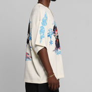 Person wearing a white shirt with blue and red designs on a gray background