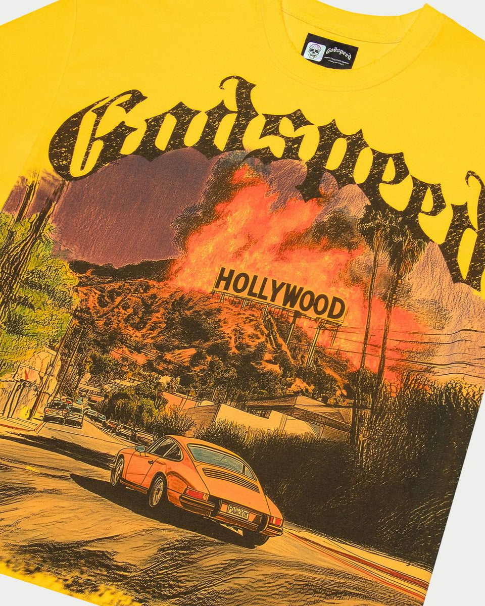 Yellow t-shirt with a graphic design of a car and Hollywood sign.