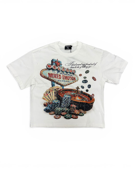 A white short-sleeve graphic t-shirt featuring a Las Vegas 'Welcome to Fabulous City of Mixed Emotion' sign surrounded by poker chips and a roulette wheel.