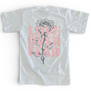 White t-shirt with a rose graphic and 'Love Over Fear' text on a white background