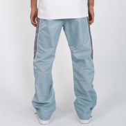 Light blue pants with gray stripes worn by a person on a white background