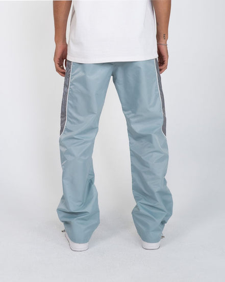 Light blue pants with gray stripes worn by a person on a white background