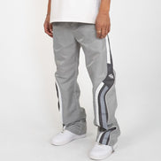 Person wearing gray track pants with white stripes on a white background