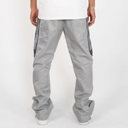 Person wearing gray pants with side stripes on a white background