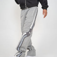 Person wearing gray track pants with white stripes on a white background