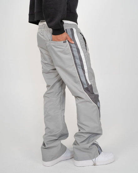 Gray tracksuit pants with white stripes on a white background