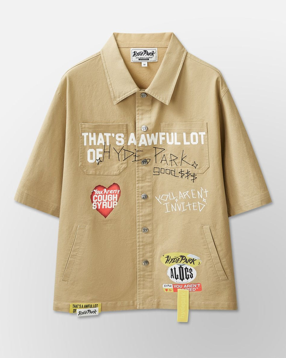 Beige shirt with text and graphic designs on a light gray background
