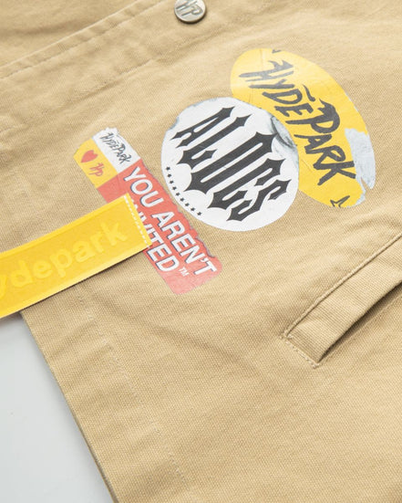 Close-up of a beige jacket with various stickers on a light gray background