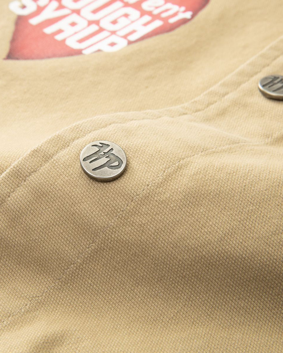 Close-up of a beige jacket with a button and visible brand logo.