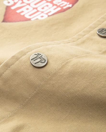 Close-up of a beige jacket with a button and visible brand logo.