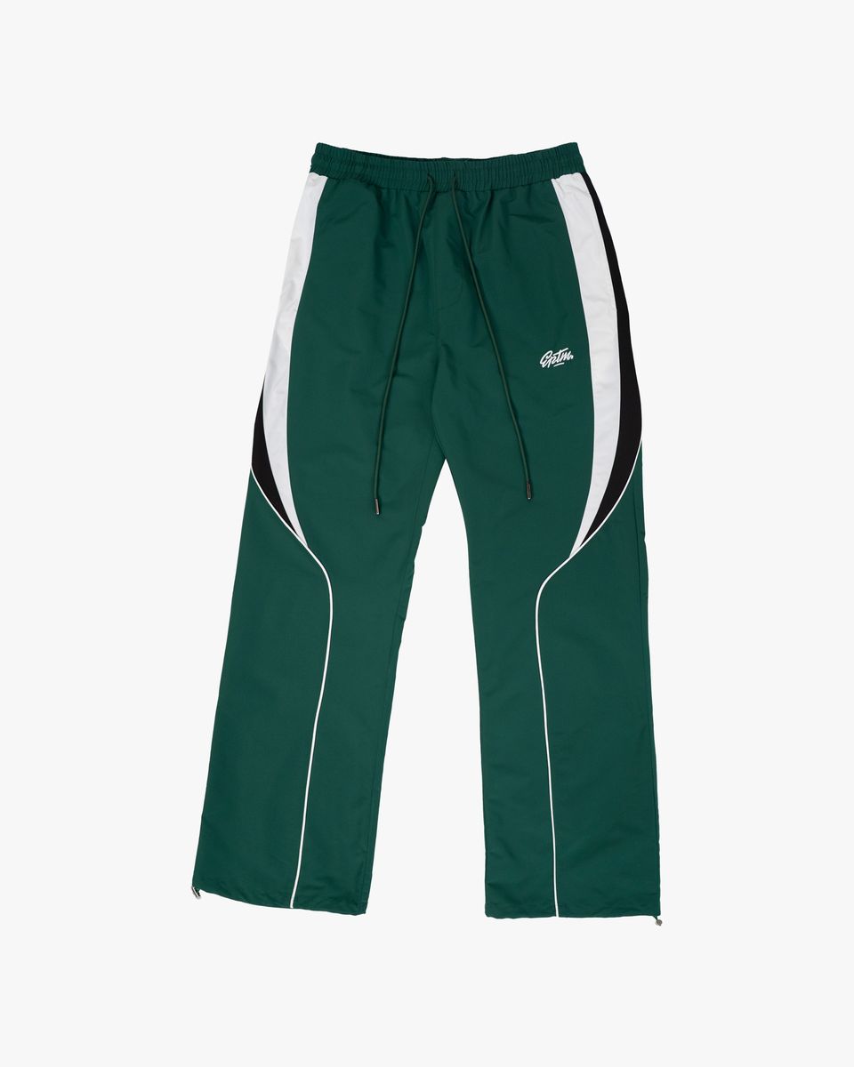 Green track pants with white side panels on a white background