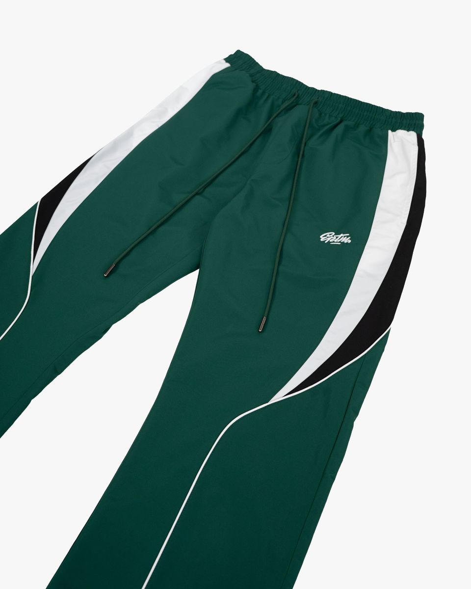 Green and white tracksuit pants with a brand logo on a white background