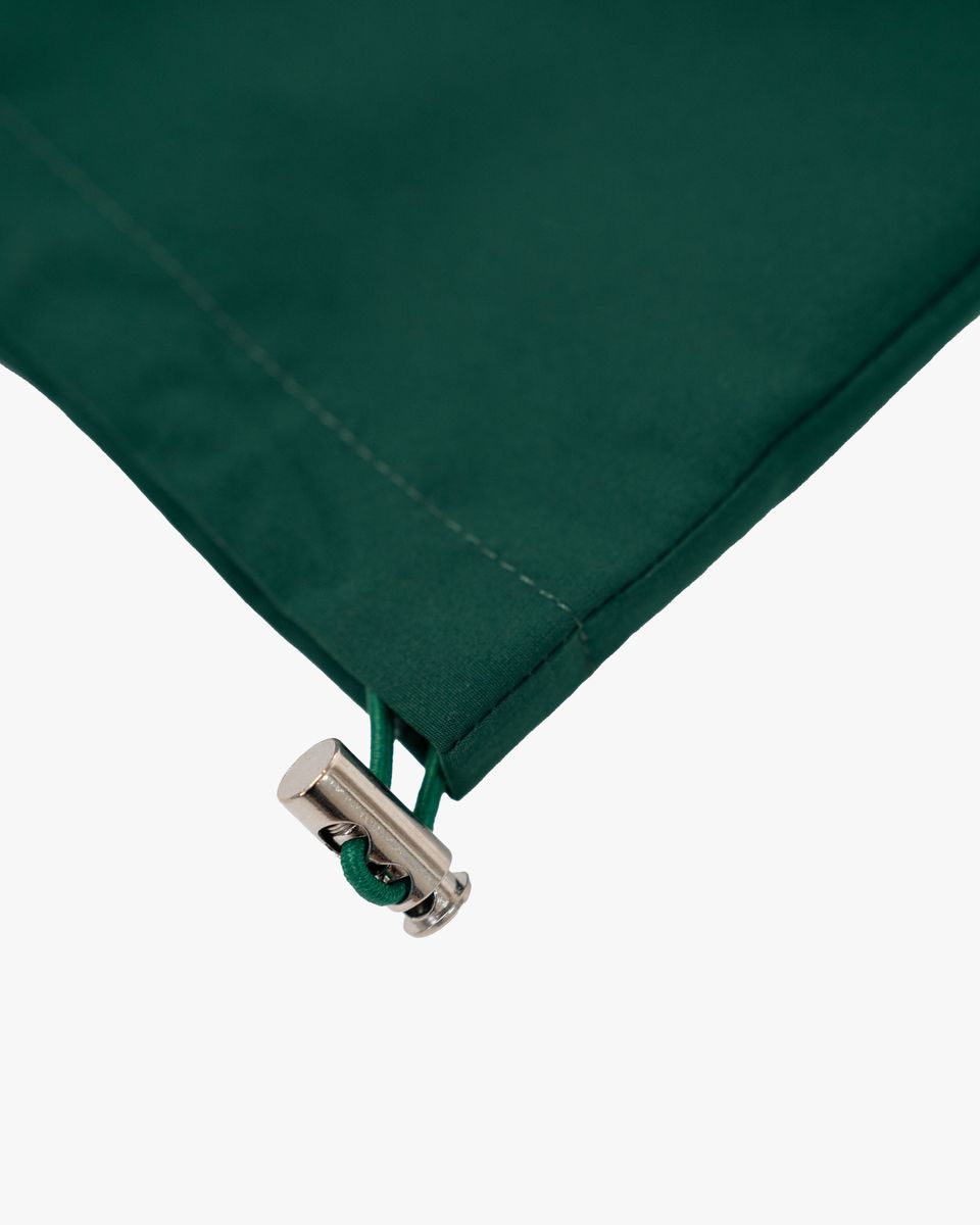Close-up of a green fabric with a metal zipper on a white background