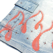 Denim shorts with flame designs and studs on a white background