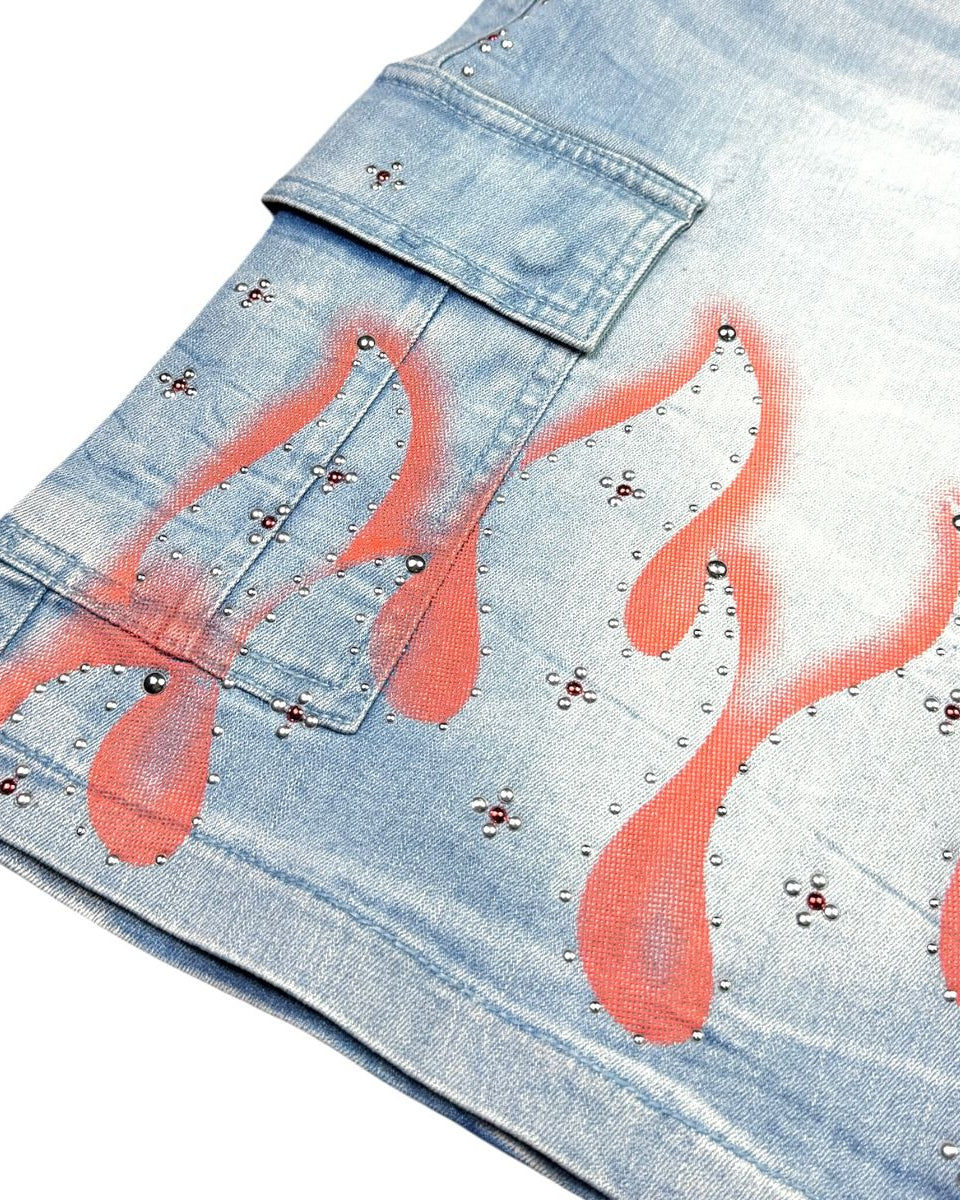 Denim shorts with flame designs and studs on a white background