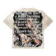 A short-sleeve graphic t-shirt shown from the back, featuring a distressed beige and white base with a large black-and-white graphic of a crucified figure overlaid with gothic text.