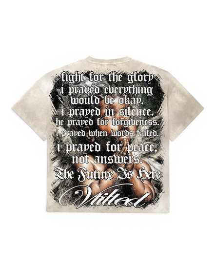 A short-sleeve graphic t-shirt shown from the back, featuring a distressed beige and white base with a large black-and-white graphic of a crucified figure overlaid with gothic text.