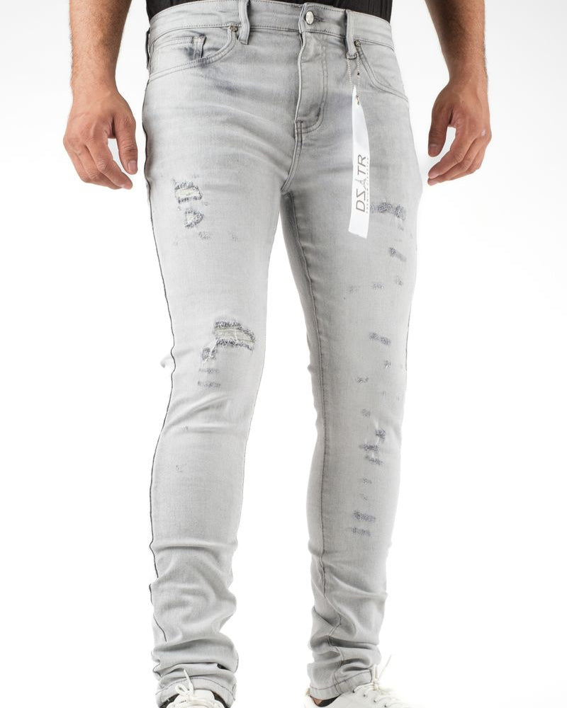 Light gray distressed jeans worn by a person on a white background