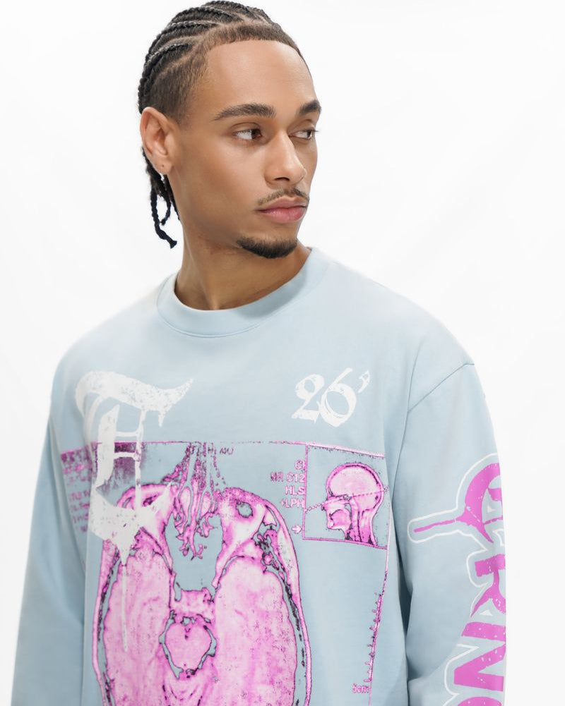 Man wearing a light blue sweatshirt with pink and white graphics on a white background
