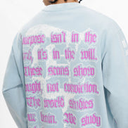 Person wearing a light blue sweatshirt with pink text on the back against a white background