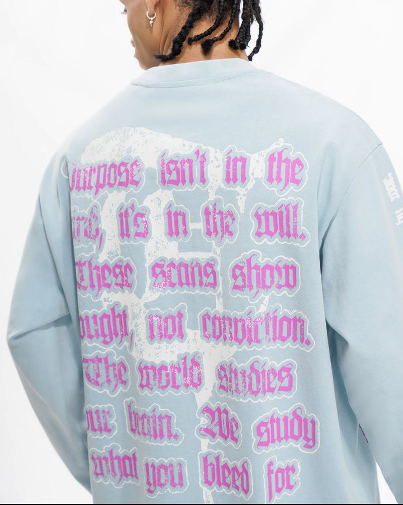Person wearing a light blue sweatshirt with pink text on the back against a white background