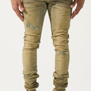 Person wearing beige distressed jeans and white sneakers on a white background