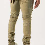Person wearing beige jeans and white sneakers on a light background