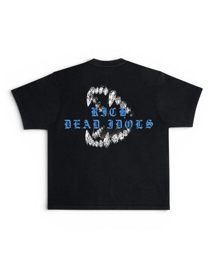 A black short-sleeve t-shirt shown flat against a white background, featuring a graphic on the back with a circular arrangement of white teeth and blue gothic-style text reading 'RICH DEAD IDOLS'.