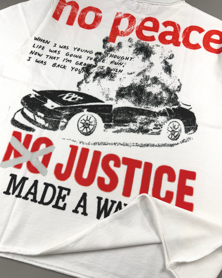 White graphic t-shirt featuring a distressed black and red print with the text 'no peace NO JUSTICE MADE A WAY' and an image of a smoking car.