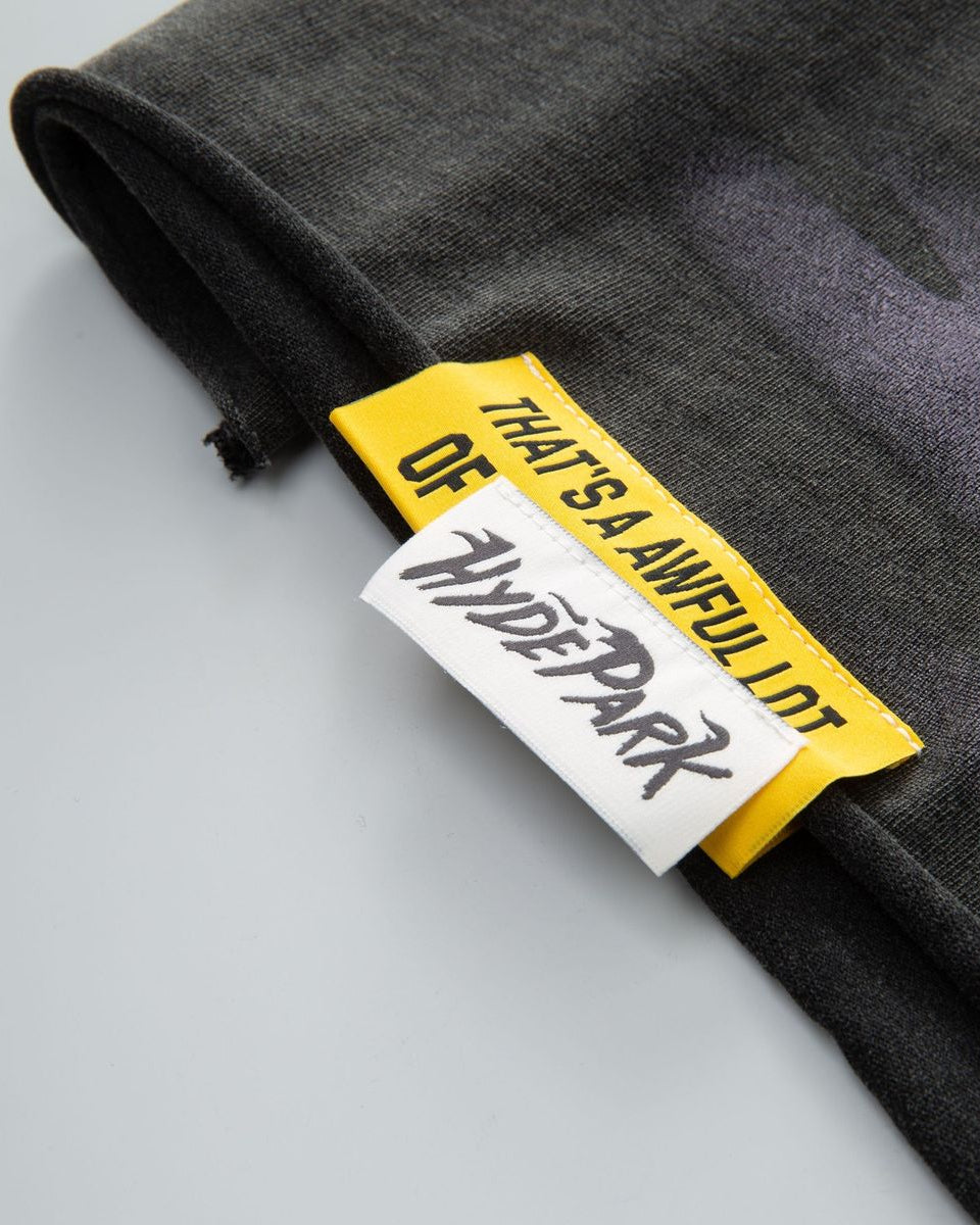 Close-up of a black garment with a yellow and white label on a light gray background